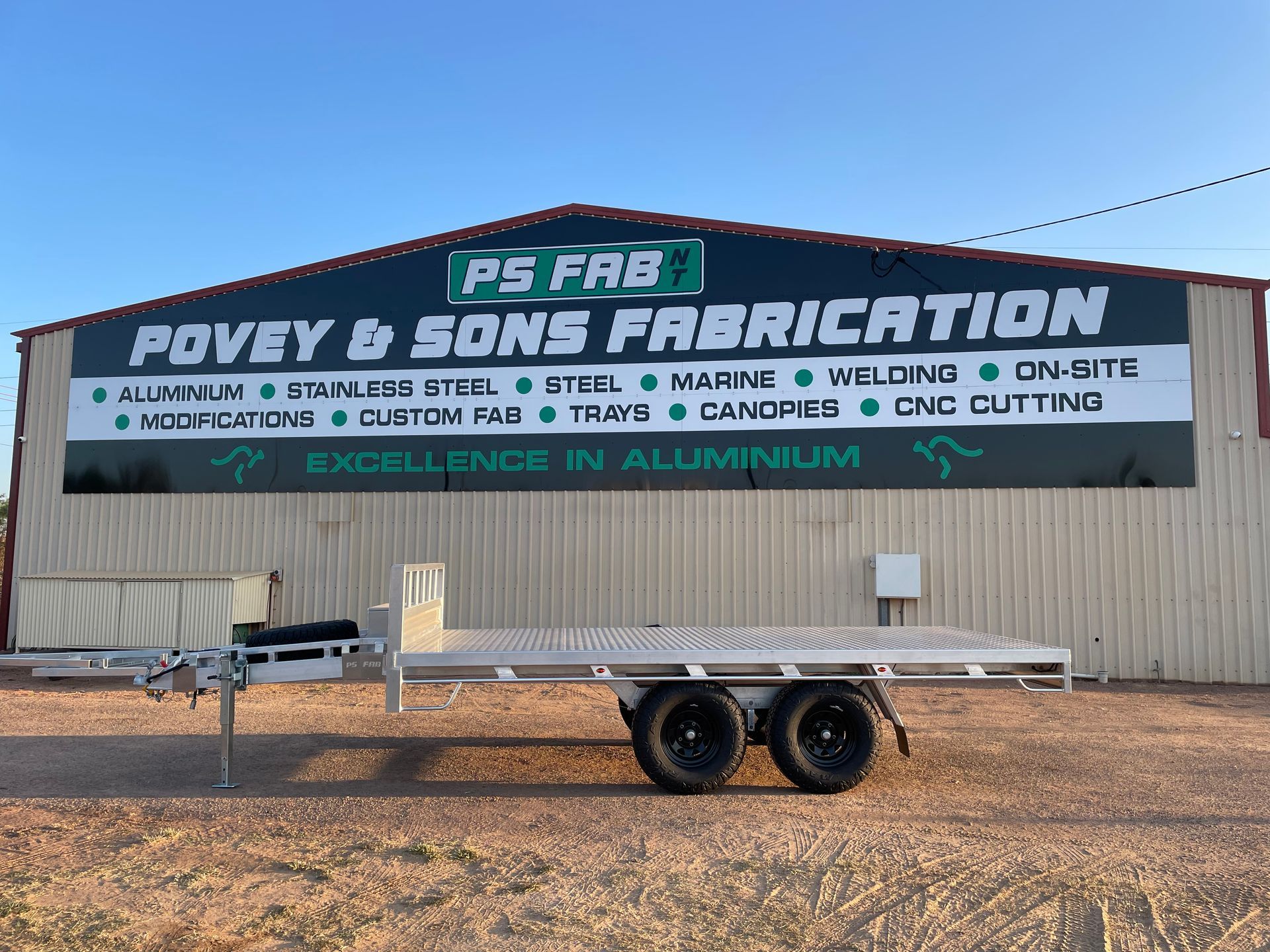 FS FAB and Foyev & Sons Fabrication sign on a metal building with trailer in front