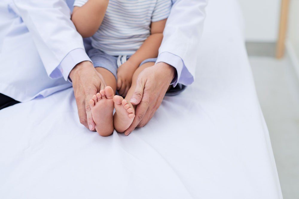 Doctor Holding Child's Feet — Indianapolis, IN — Northeast Foot And Ankle Doctor Holding Child's Feet — Indianapolis, IN — Northeast Foot And Ankle