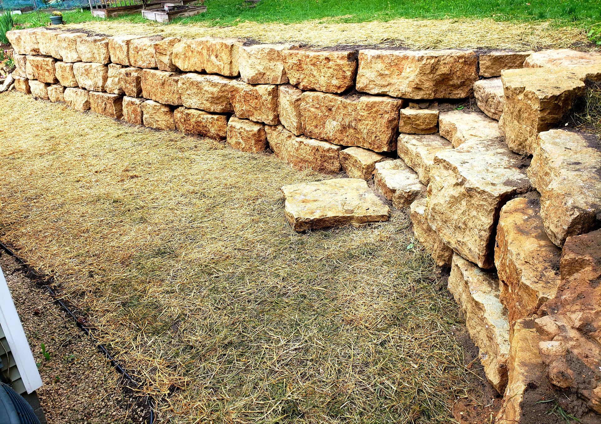 A stone wall is sitting in the middle of a grassy field.
