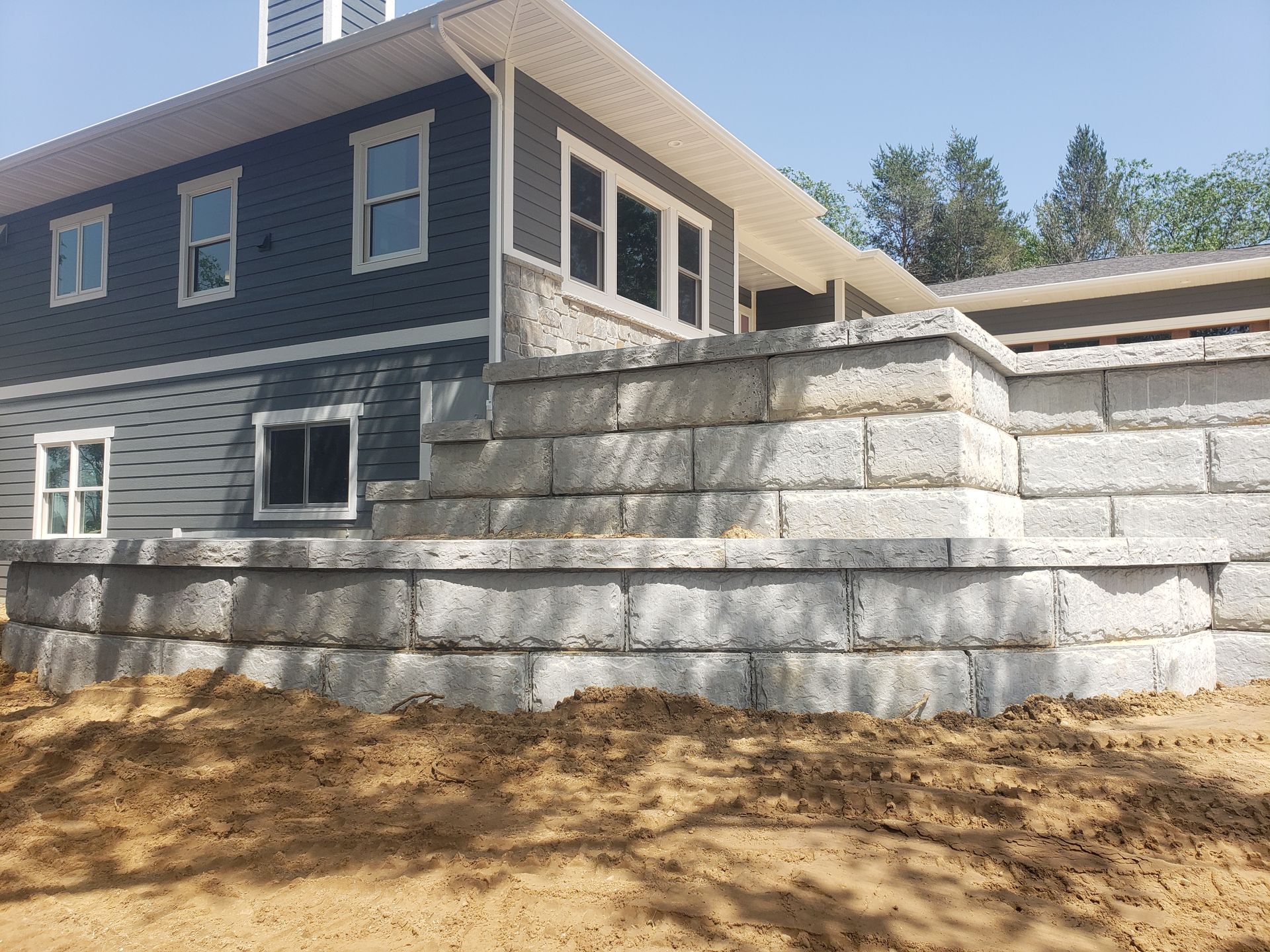 A large brick wall is in front of a house.