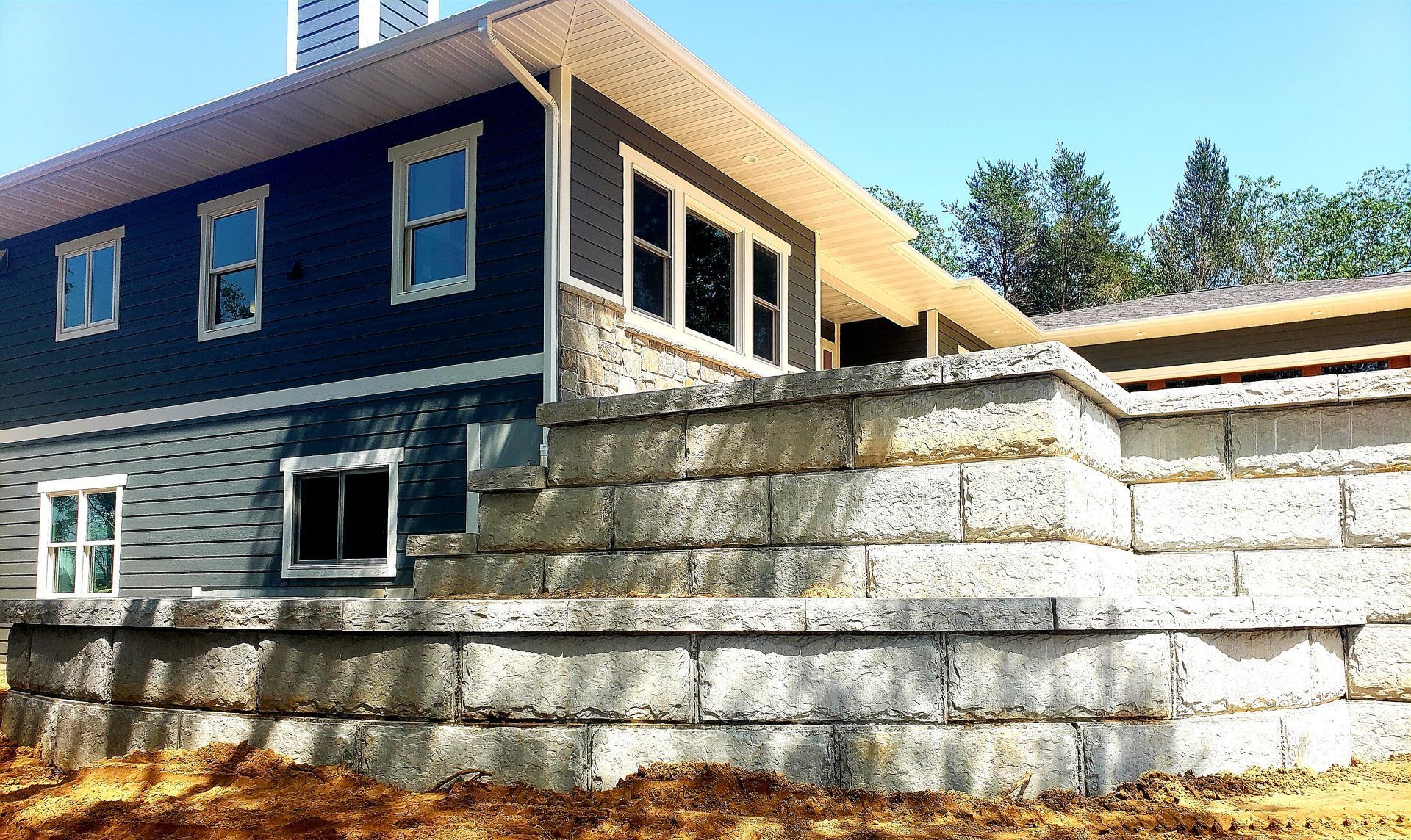 A house under construction with a brick wall in front of it