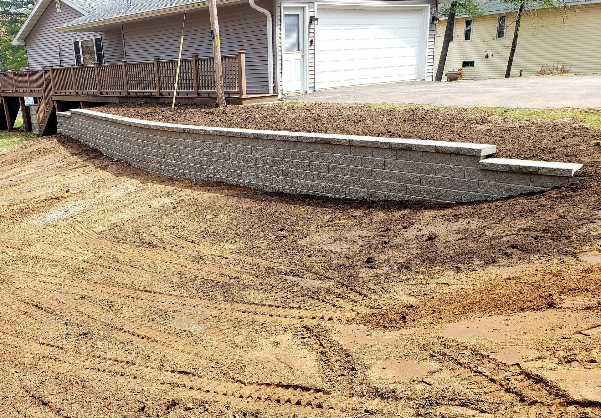 A stone wall is being built in front of a house.