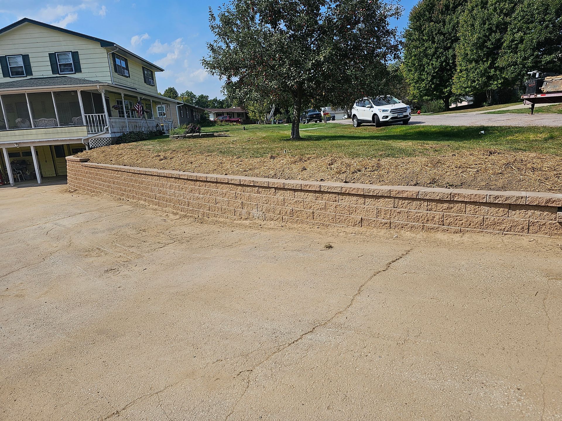 A white suv is parked in front of a large house.