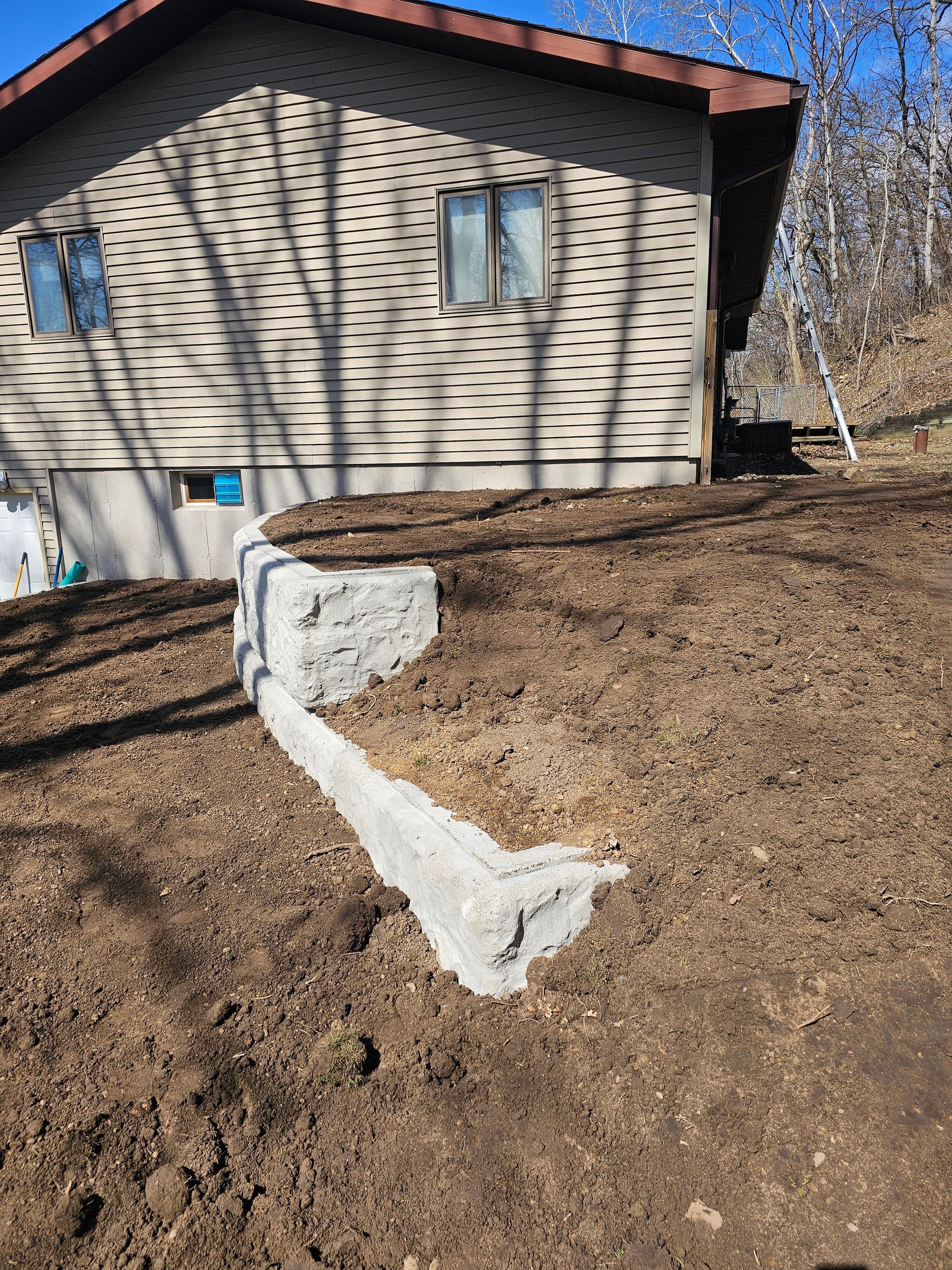 A house is sitting on top of a dirt hill.