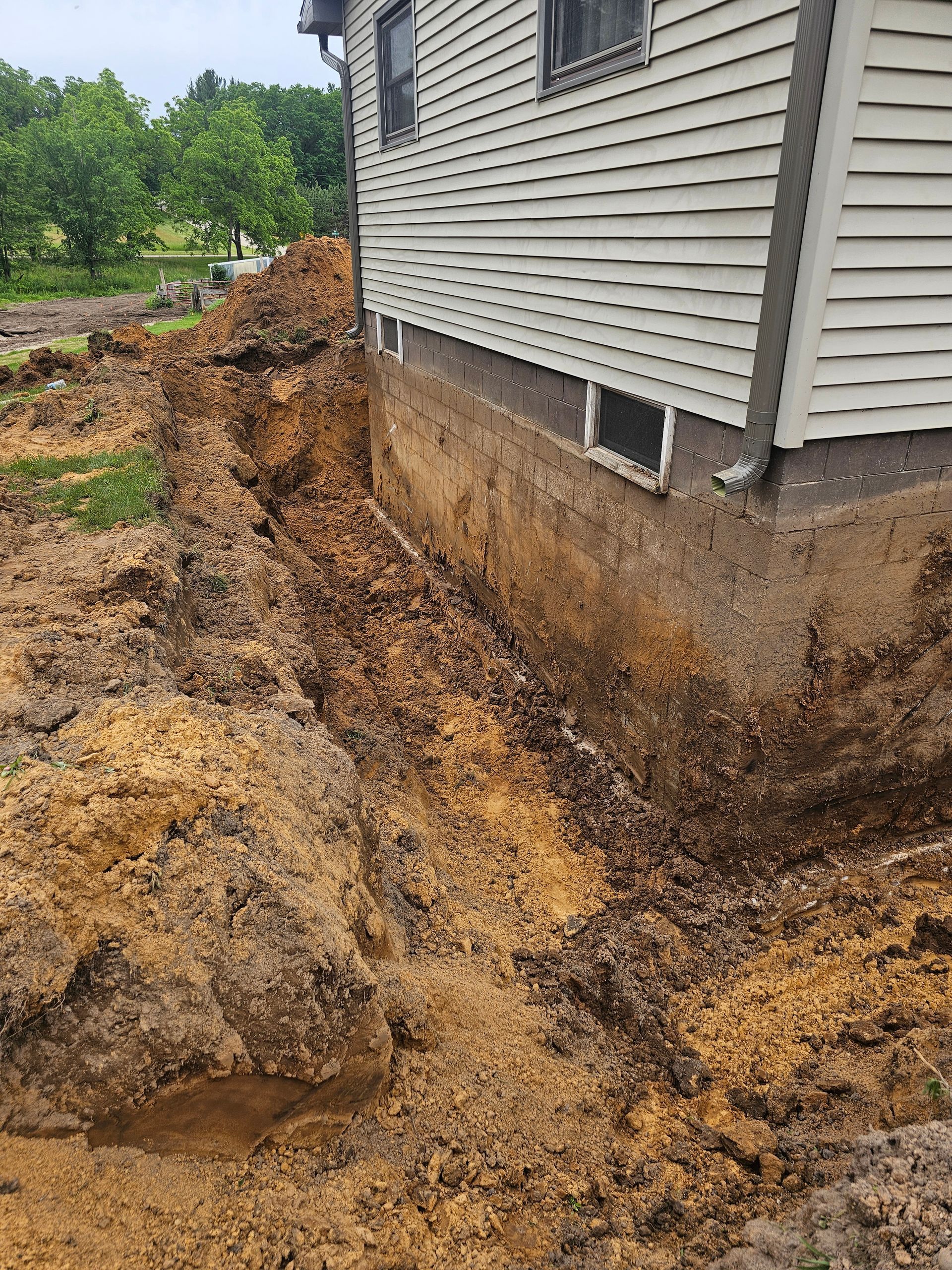 A house with a lot of dirt on the side of it.