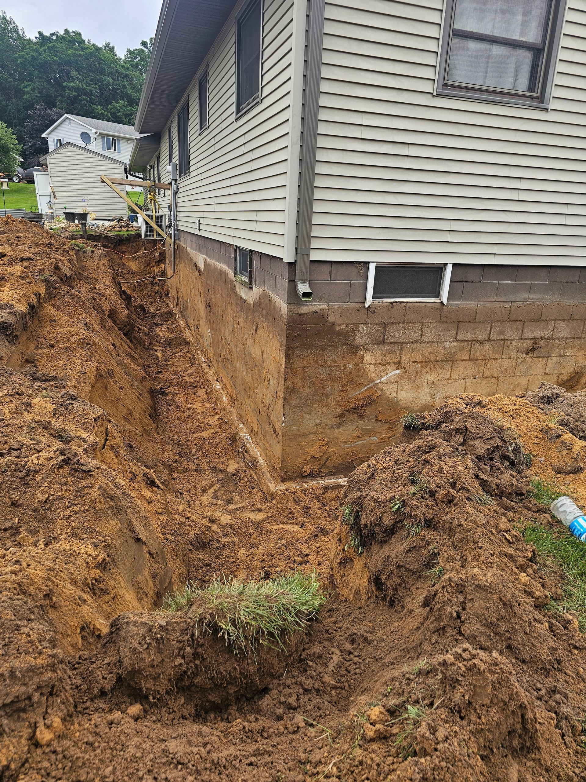 A large pile of dirt is sitting in front of a house.