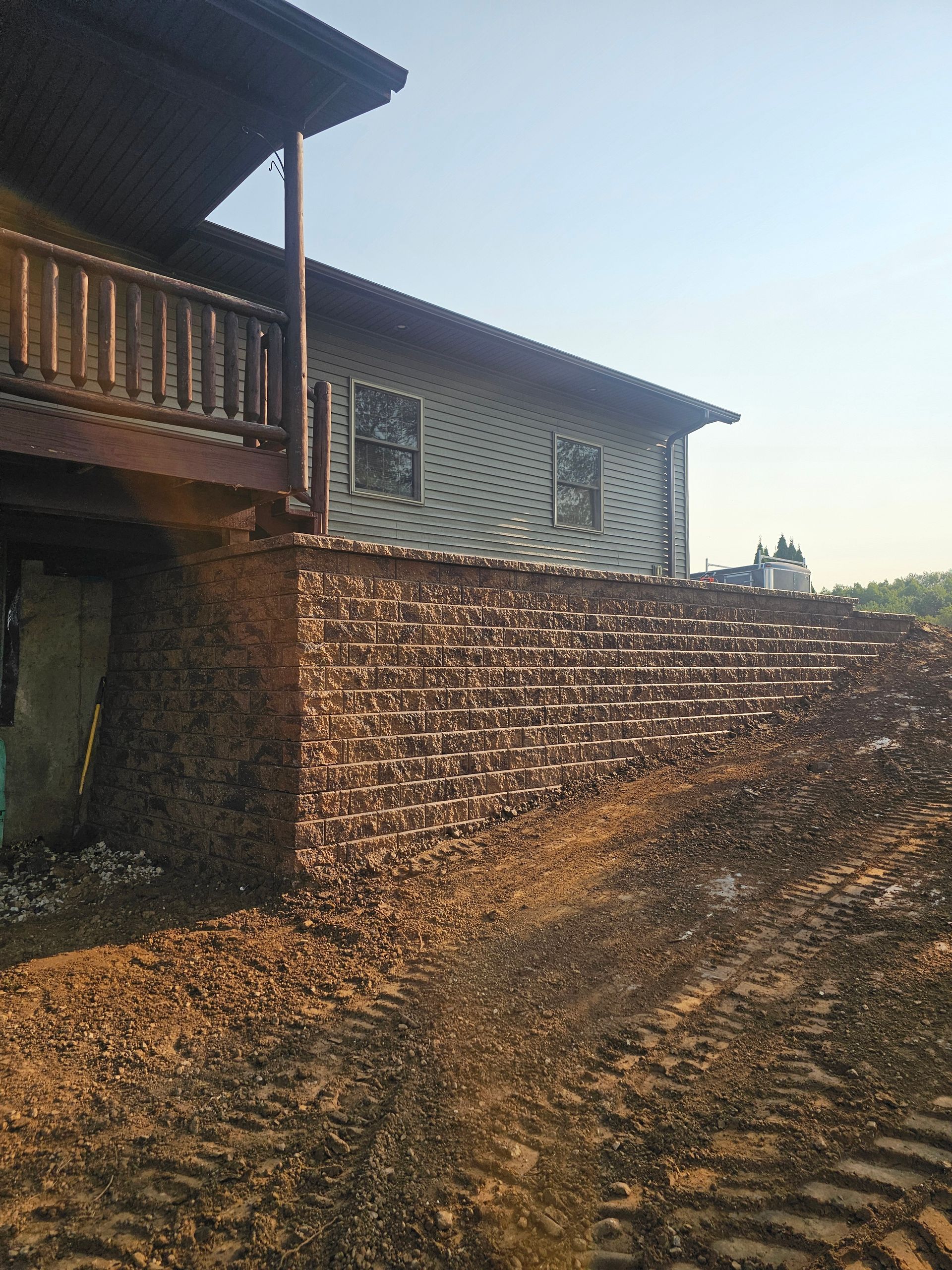 A large house with a brick wall and a wooden deck.