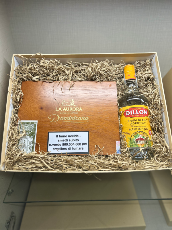 Scatola regalo con sigari, bottiglia di rum Dillon e cannuccia.