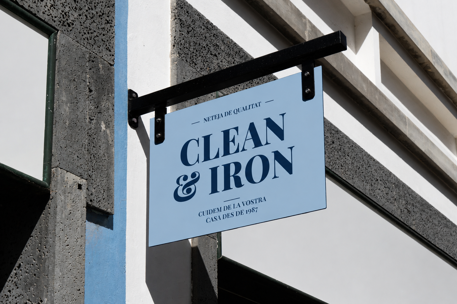 Un cartel azul colgante con la inscripción “LIMPIEZA Y PLANCHADO” en la fachada de un edificio.