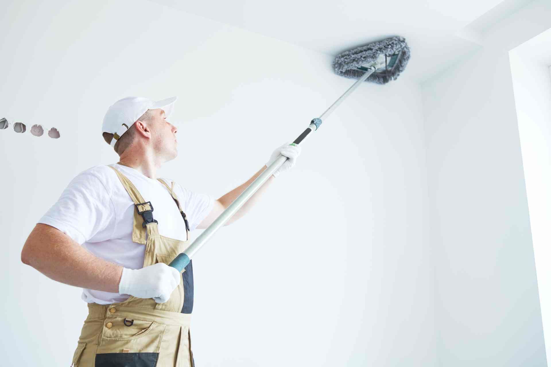 Painter using essential paint tools to prep before applying paint to the walls and ceiling at Steve