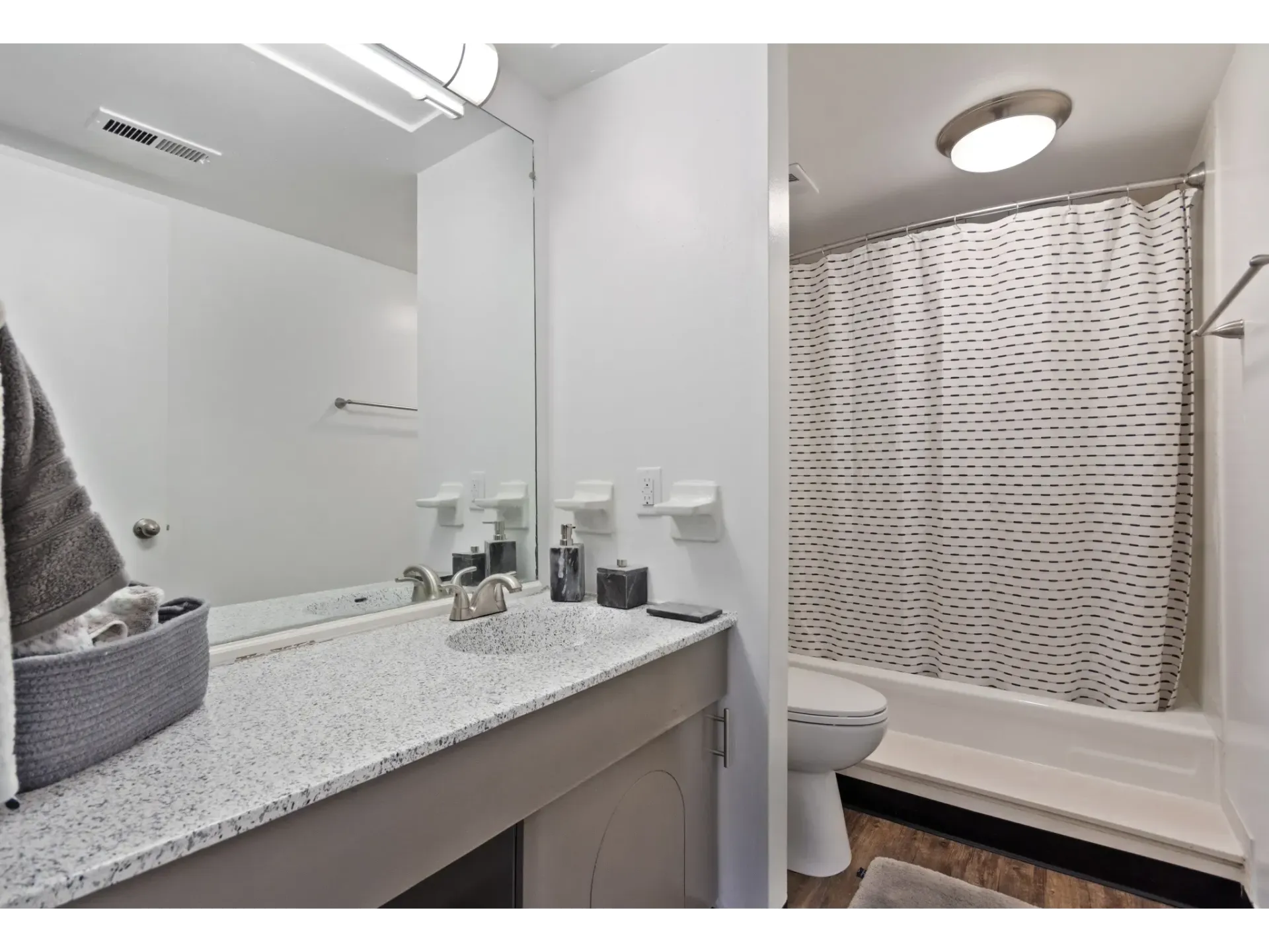 A modern bathroom featuring a countertop sink, mirror, and shower area.
