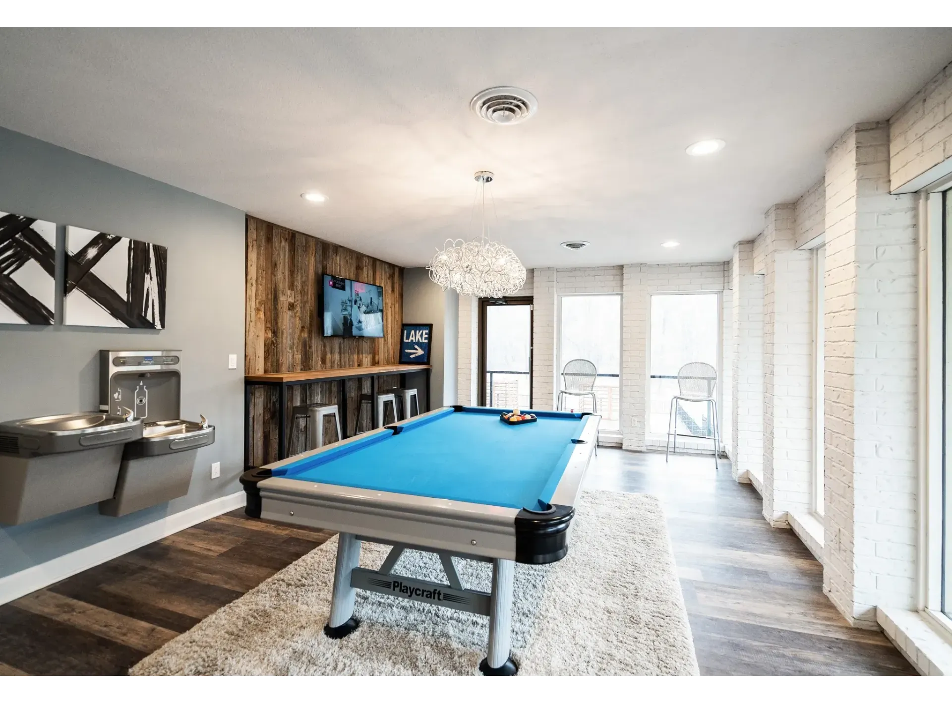 Indoor game room with a blue pool table, TV, and seating area.