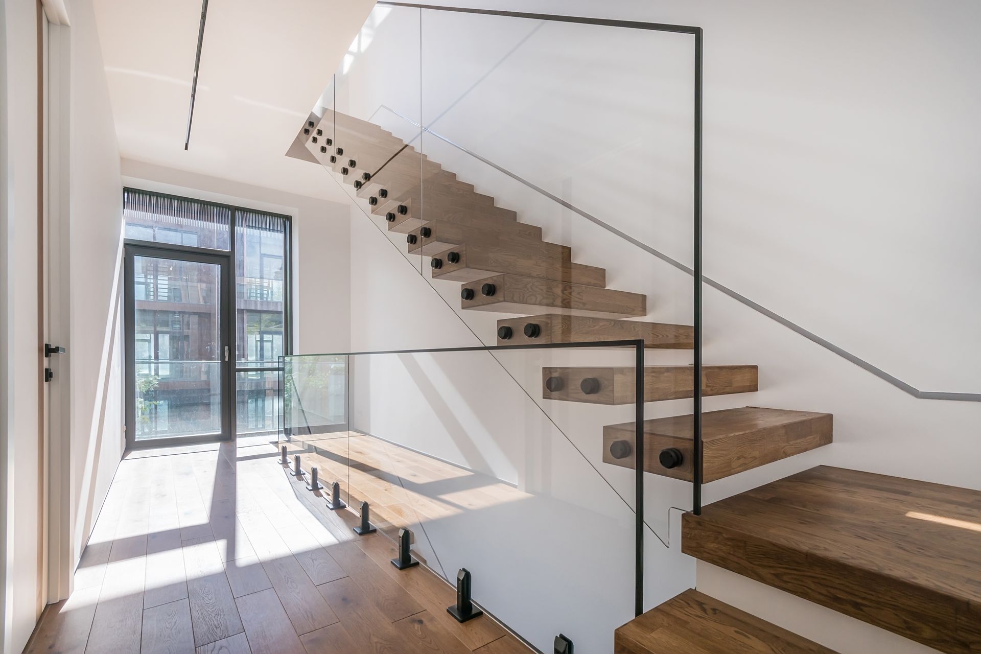 Modern stairway with glass railing in a bright minimalist interior