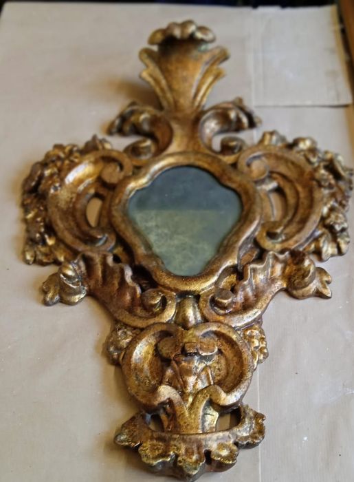 Specchio da parete ornato con cornice dorata e dettagli floreali intagliati