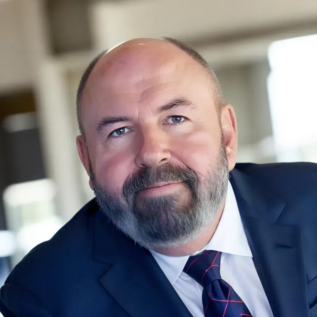 A bald man with a beard wearing a suit and tie
