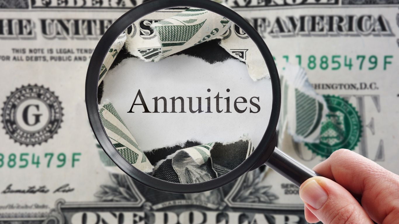 A person is holding a magnifying glass over a dollar bill that says annuities