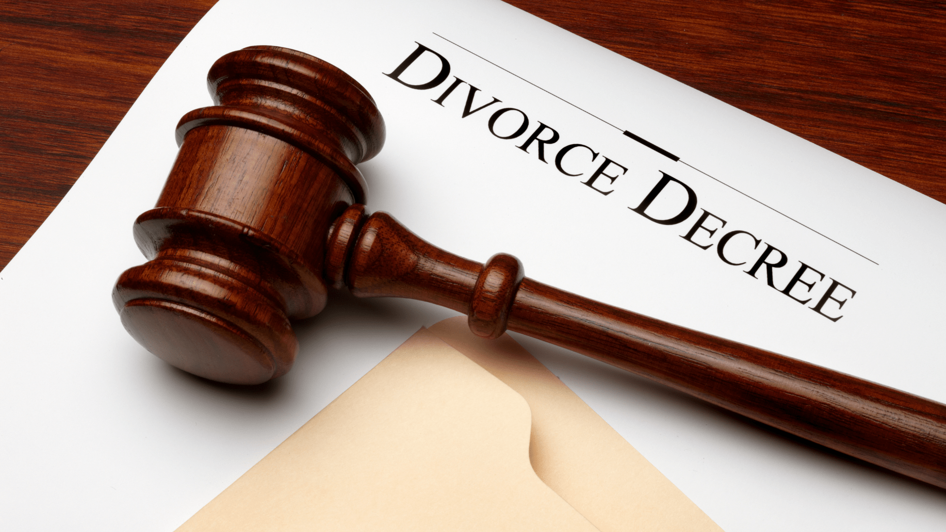 A wooden gavel is sitting on top of a divorce decree