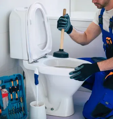 Toilet clogged - plumber is unclogging it with plunger.