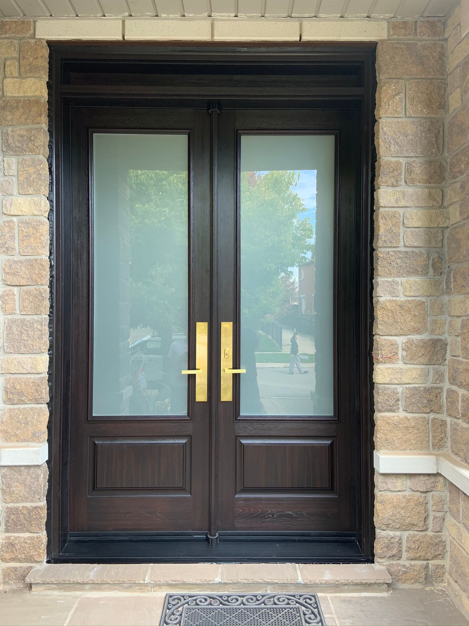A front door with a brick wall behind it