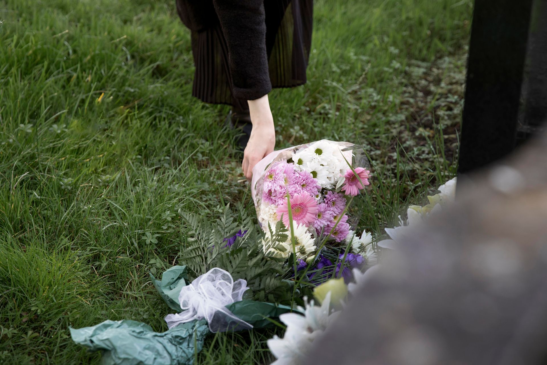 Pessoa deixa flores em um túmulo no Dia de Finados