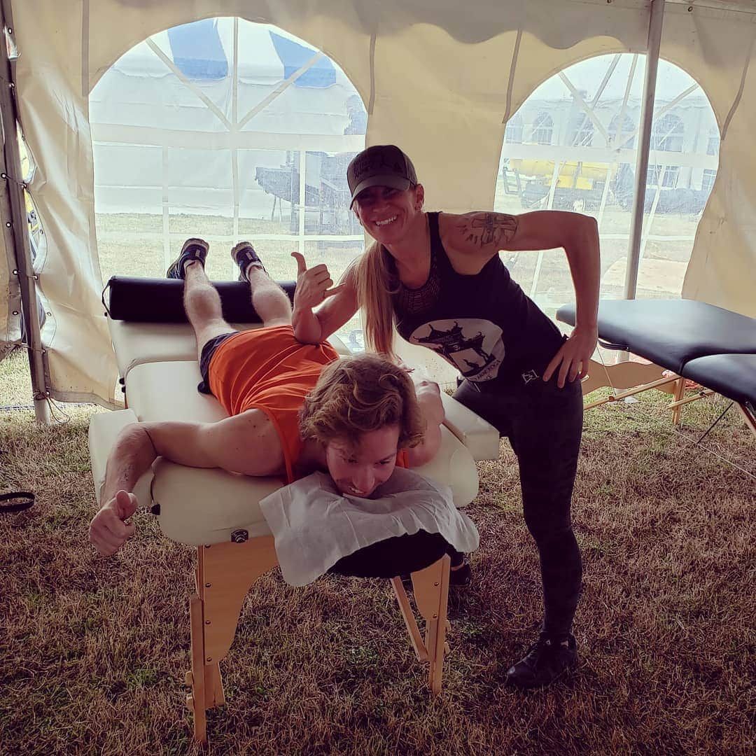A massage therapist performing abdominal massage on a client lying on a treatment table.
