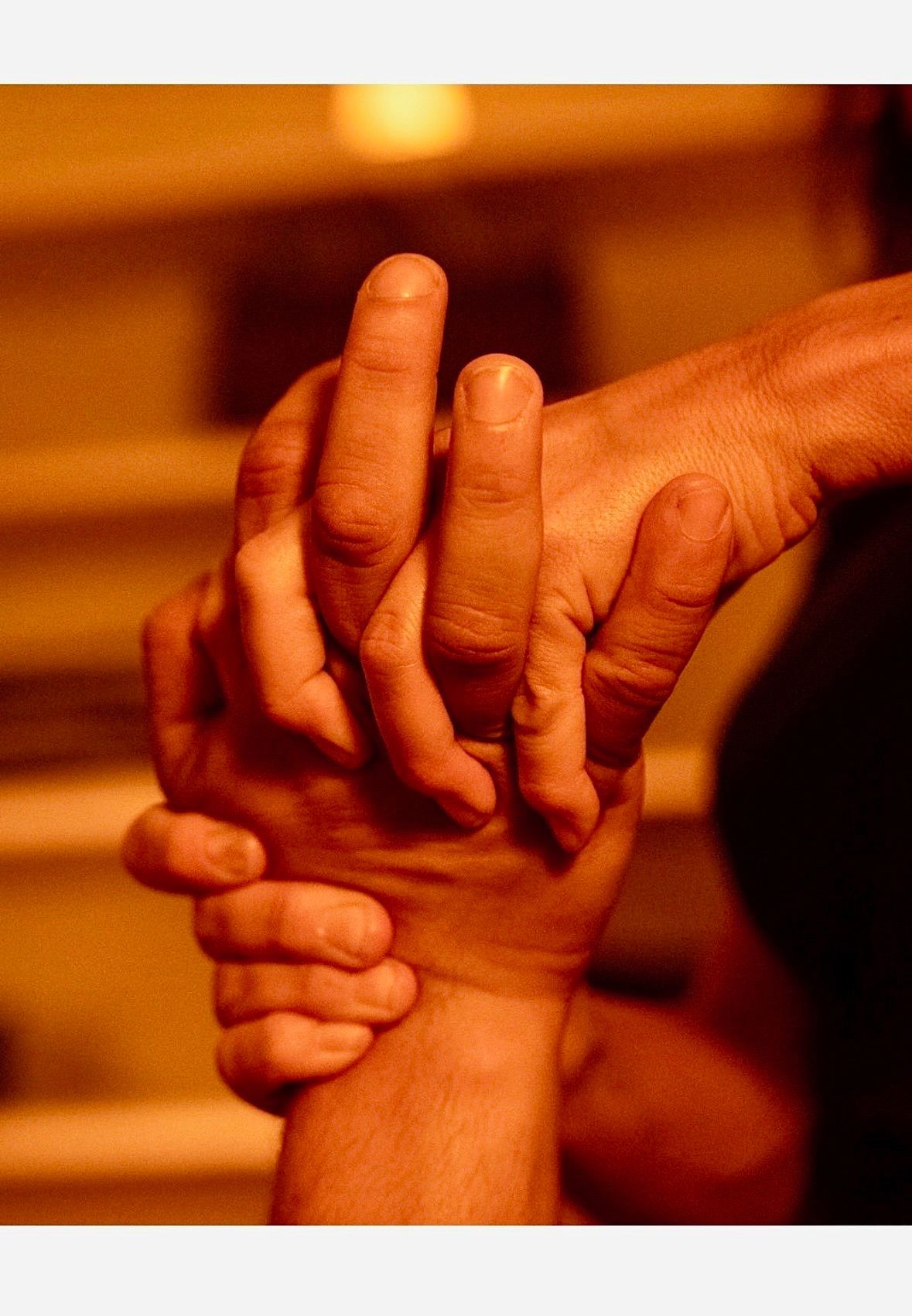 A person receives a professional massage on their back as they lie on a table.