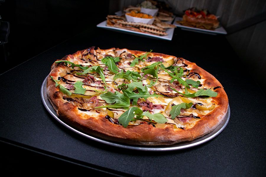 Signature White Bull pizza with prosciutto apples and arugula in Downtown Boston