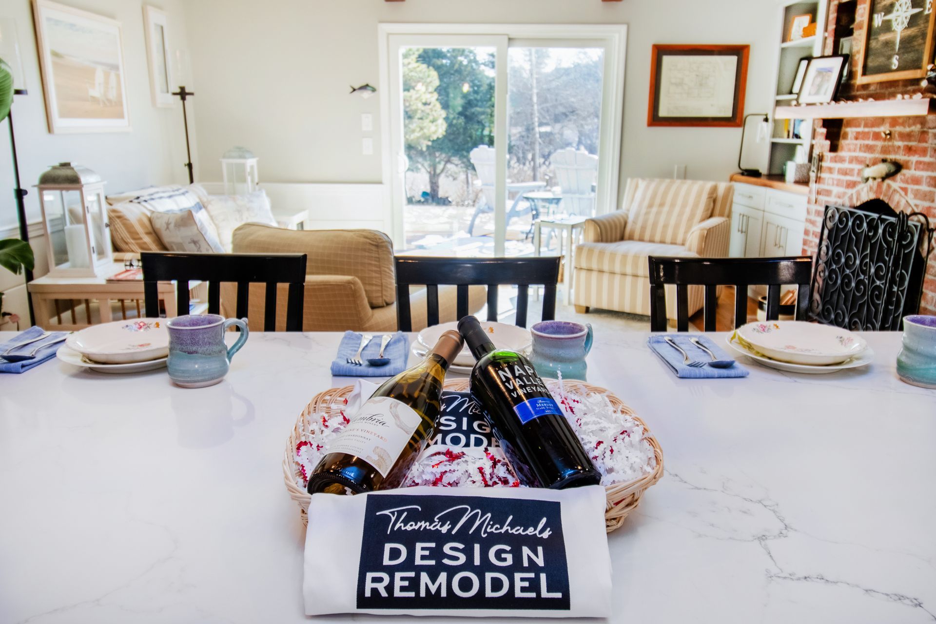 Dining room table set for a meal. Two wine bottles rest on a basket with a