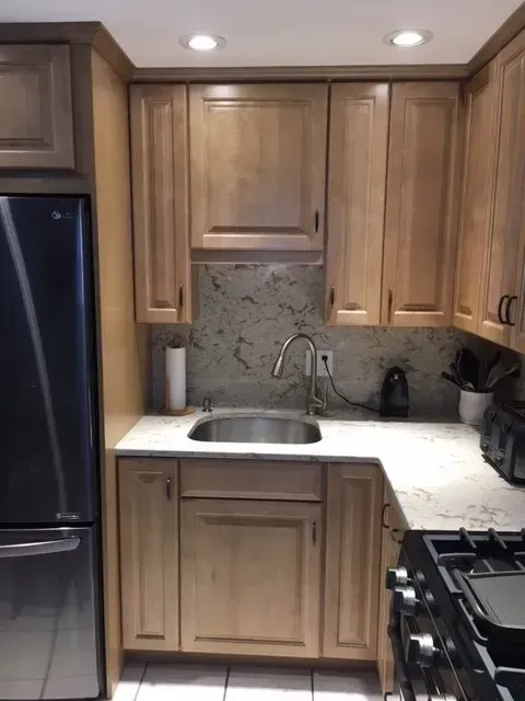 Kitchen with gray cabinets, stainless steel appliances, white countertops, and a wood ceiling.