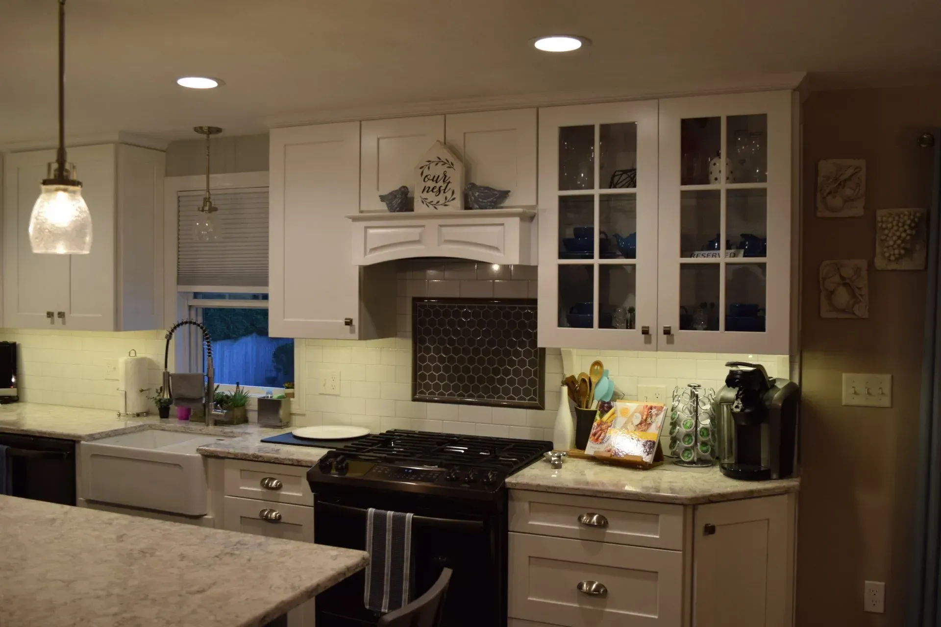 White kitchen with stove, cabinets, and island. Features glass-front cabinets with blue decor.
