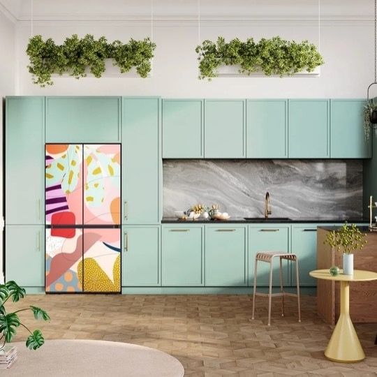 Mint green kitchen with colorful refrigerator and hanging plants.