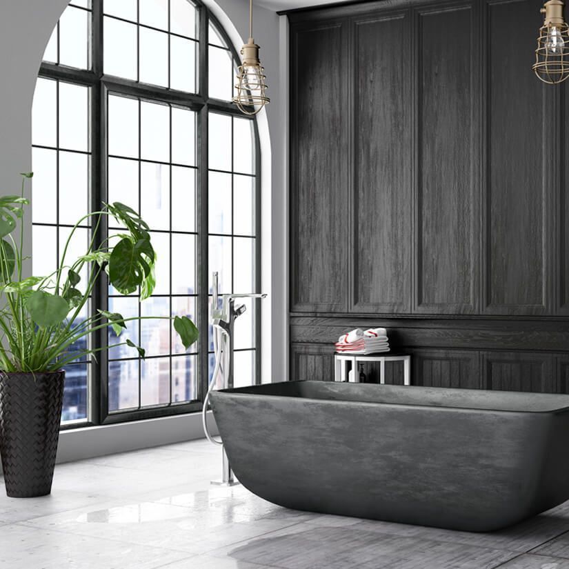 Modern bathroom with dark gray soaking tub, black accent wall, and large arched window.