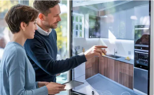 Couple interacting with a touchscreen showing a kitchen design; man pointing at countertop.
