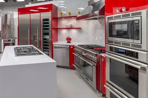 Modern kitchen with stainless steel appliances and red cabinetry.
