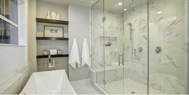 Modern bathroom with marble shower, bathtub, shelves, and white towels.