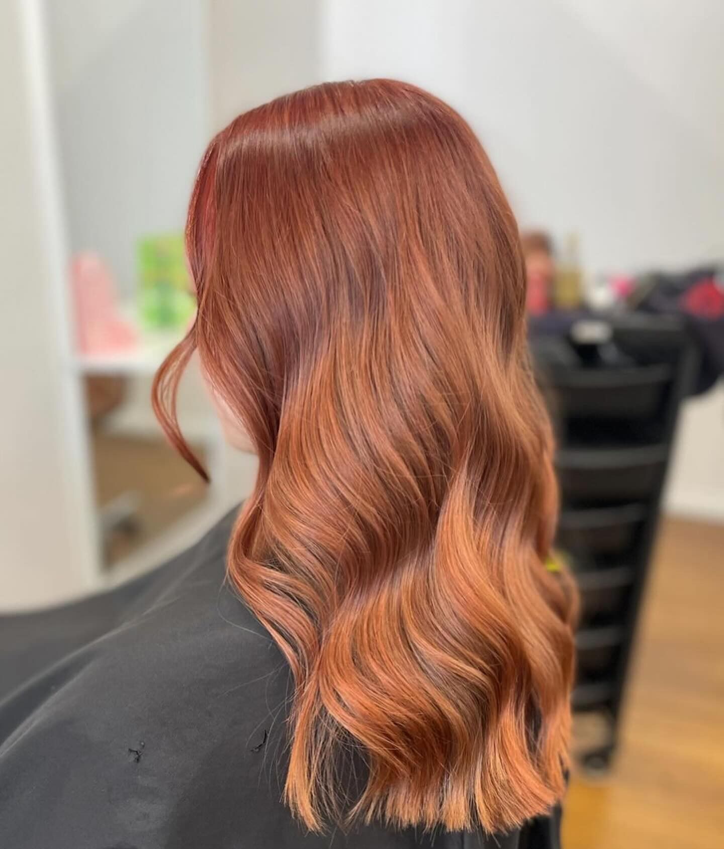 Wavy Copper-Red Shoulder-Length Haircut Viewed from The Back in A Salon Chair — Pose Hair Design in Orange, NSW