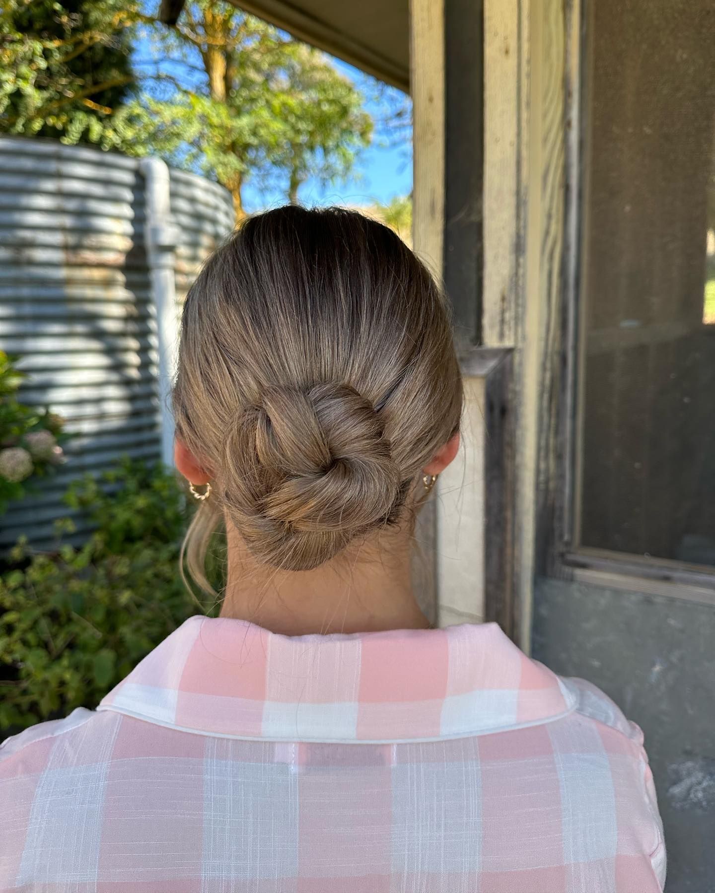 Blonde Hair in A Low Twisted Bun, Viewed from Behind in A Mirror — Pose Hair Design in Orange, NSW