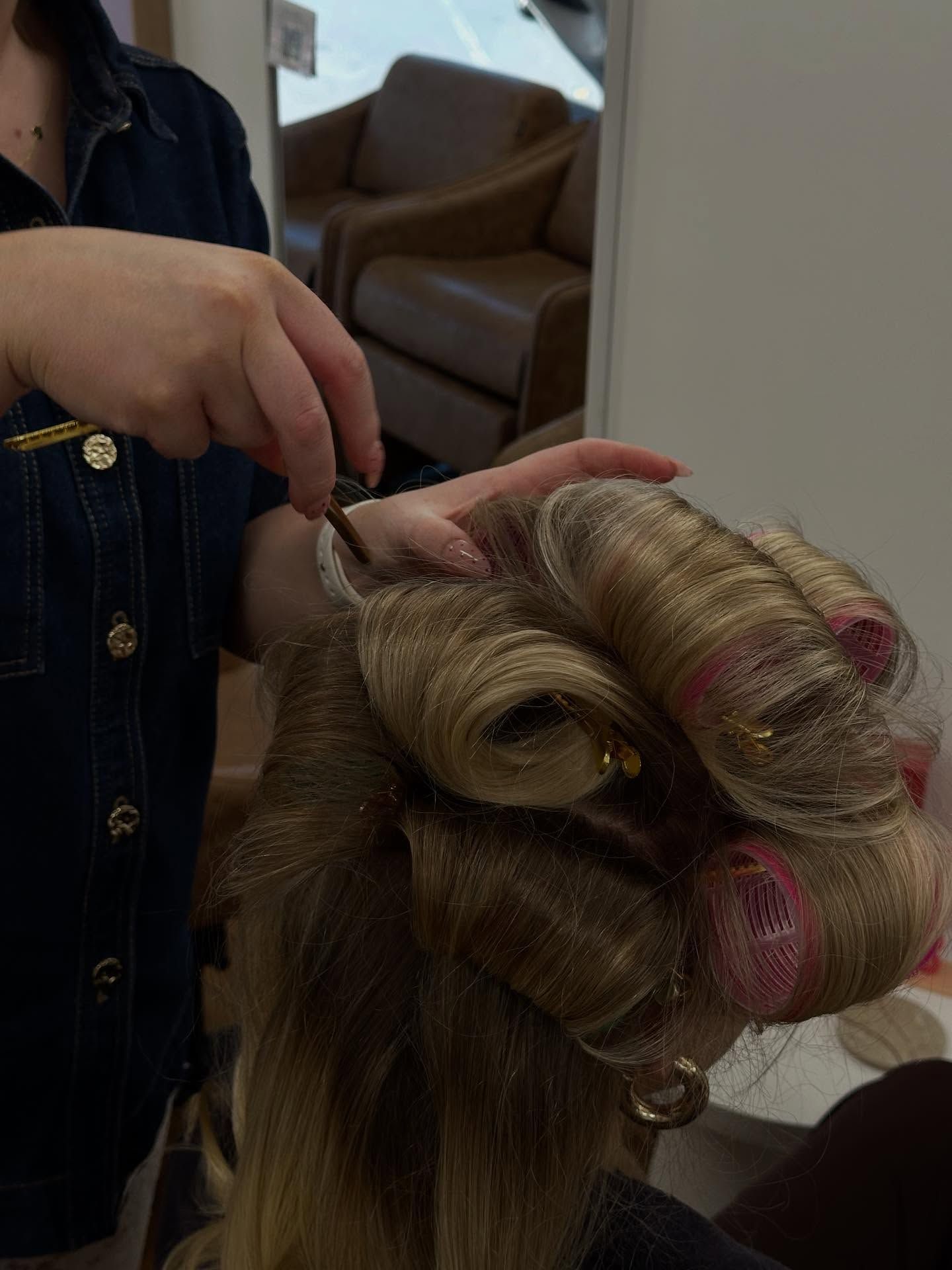 Person Holding an Ornate Blonde Braided Hair Piece with Pink Flowers Indoors — Pose Hair Design in Orange, NSW