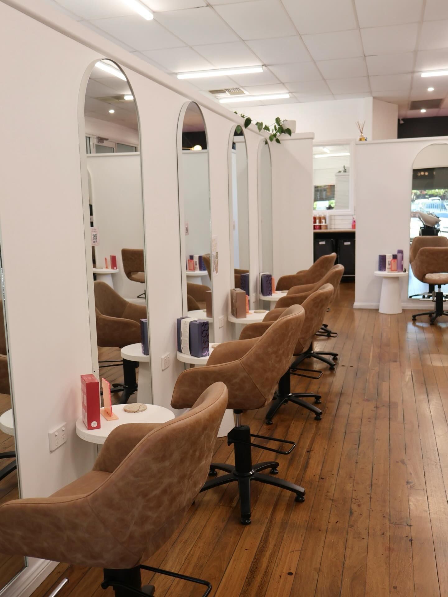Modern hair salon with styling chairs, mirrors, and wooden floors — Pose Hair Design in Orange, NSW