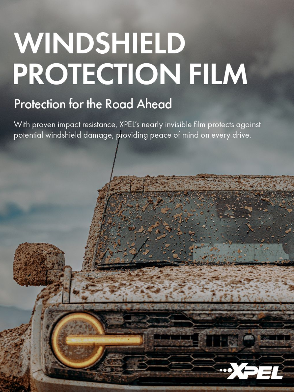 A windshield protection film is being used on a muddy truck.
