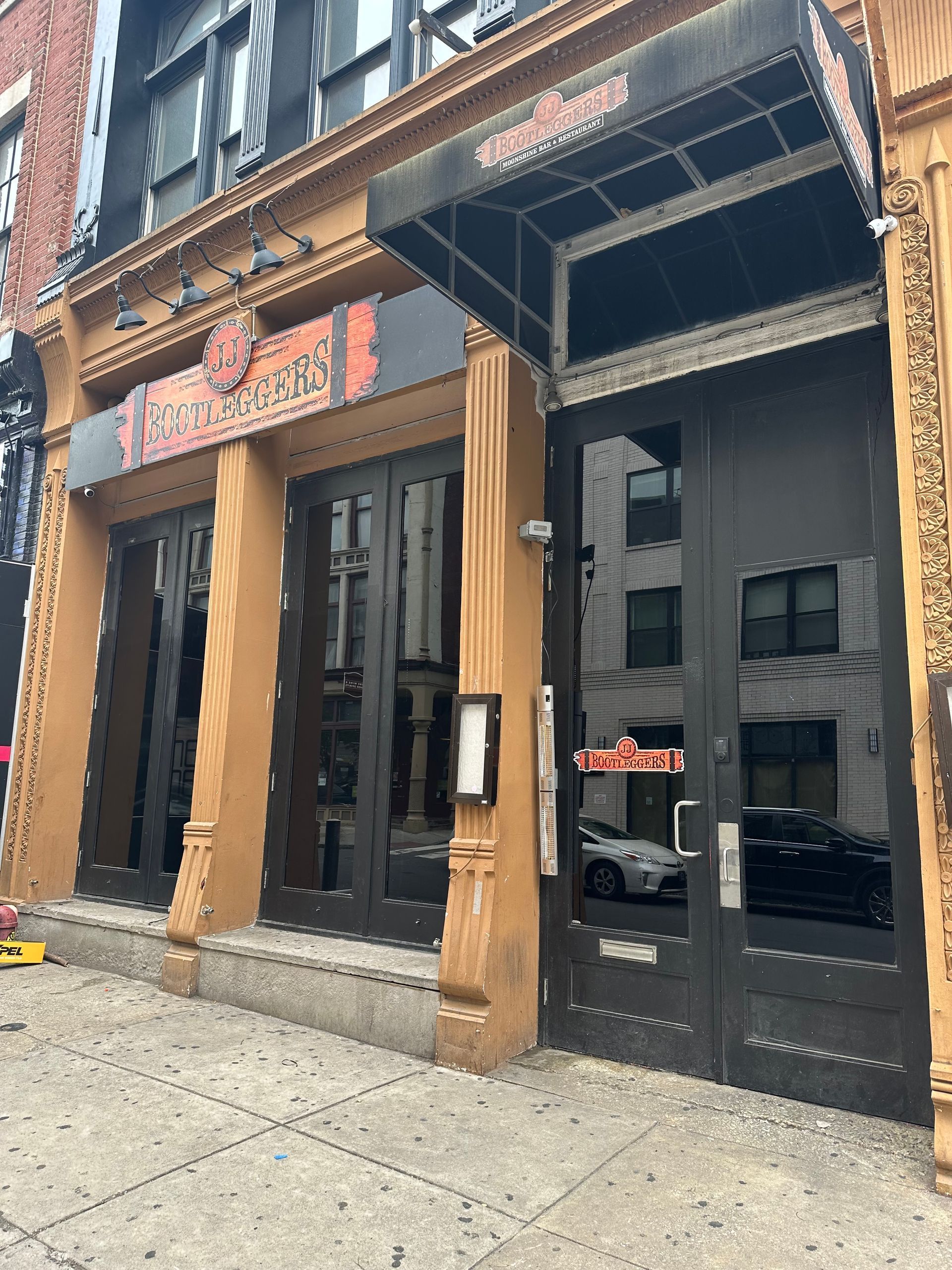 Exterior of Wonder Bar restaurant with black doors and awning, tan facade.