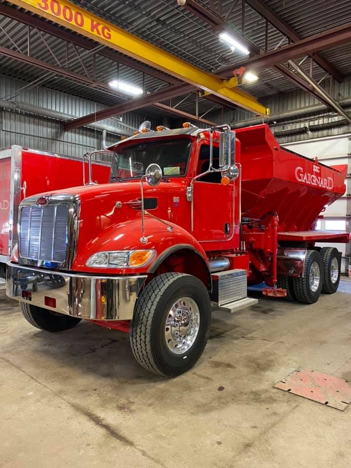 Camion industriel rouge dans un garage.