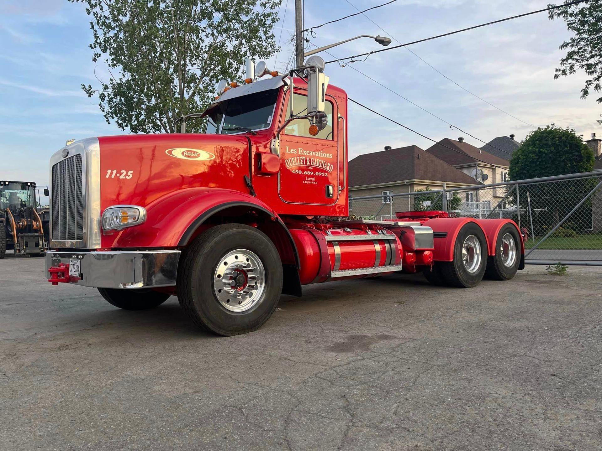 Camion semi-remorque Peterbilt rouge stationné à l'extérieur ; peinture brillante, détails chromés.