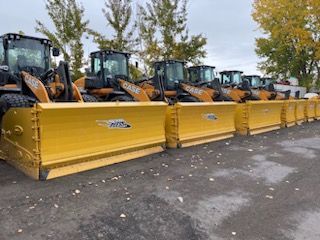 Row of yellow snowplows lined up, ready for winter.