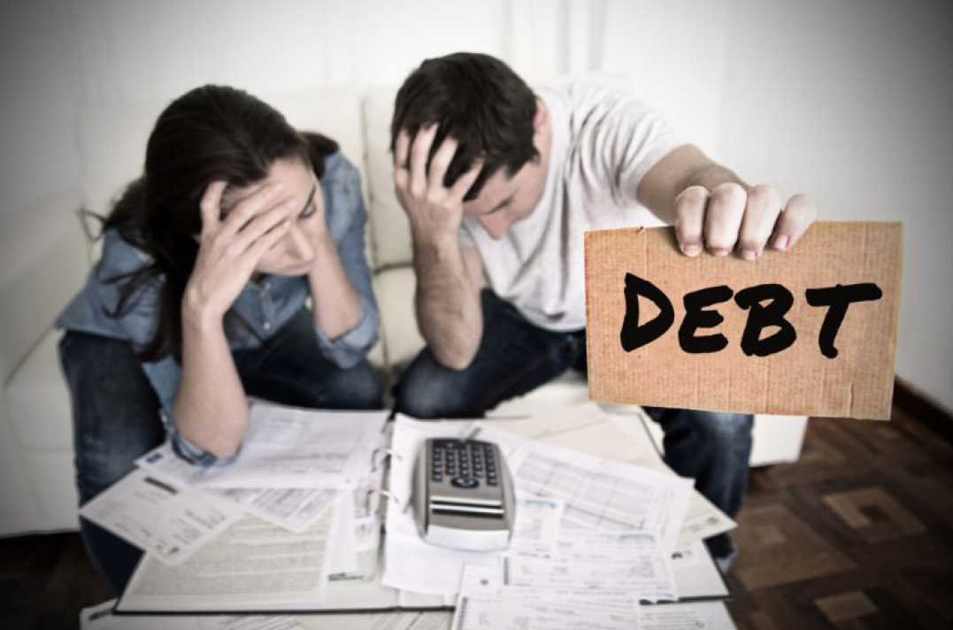 Two People Holding a Sign That Says Debt — Florissant, MO — Teague & Associates, LLC Two People Holding a Sign That Says Debt — Florissant, MO — Teague & Associates, LLC