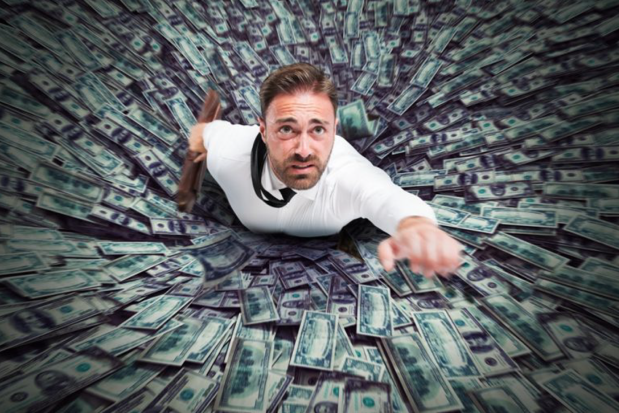 Man Staring at Many Documents — Florissant, MO — Teague & Associates, LLC A Man Sinking on Dollar Bills — Florissant, MO — Teague & Associates, LLC