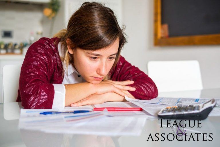 Woman Looking At Her Bills — Florissant, MO — Teague & Associates, LLC
