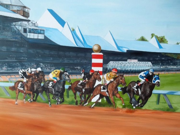 Horse race in progress, horses and jockeys near finish line, racetrack and grandstand in background.