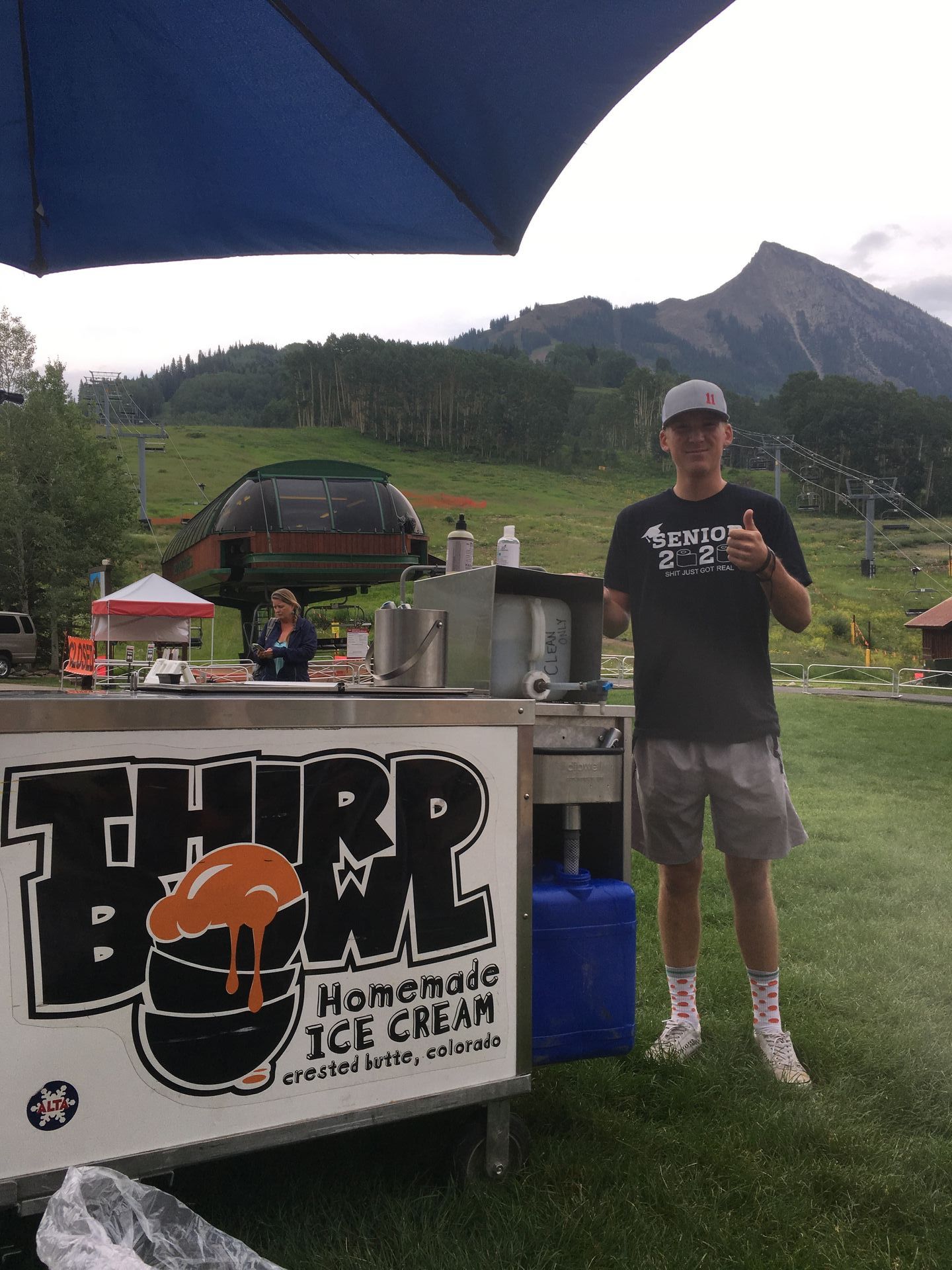 A man standing in front of a homemade ice cream cart