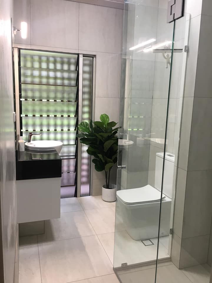 Modern Bathroom With Glass Shower, White Toilet, Vanity, and Open Window — Tropic Tiling in Tolga, QLD